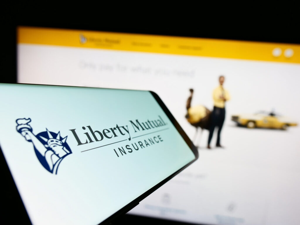 Stuttgart, Germany - 01-14-2023: Mobile phone with logo of American insurance company Liberty Mutual Group on screen in front of website. Focus on center-left of phone display.