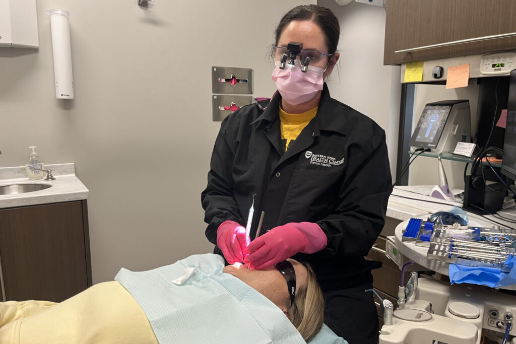 States Pay Deloitte, Others Millions To Comply With Trump Law To Cut Medicaid Rolls A dental hygienist works on a patient in a dental chair.